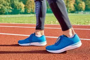 mujer con calzado deportivo en una pista de atletismo 