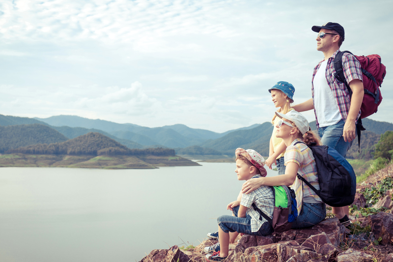 Una familia descansa al lado de un lago después de una excursión de verano