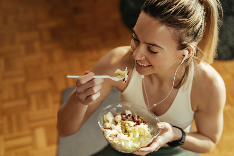 Deportista comiendo un plato fresco y nutritivo en verano