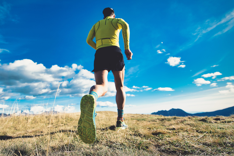 Un hombre corriendo por la montaña con zapatillas deportivas